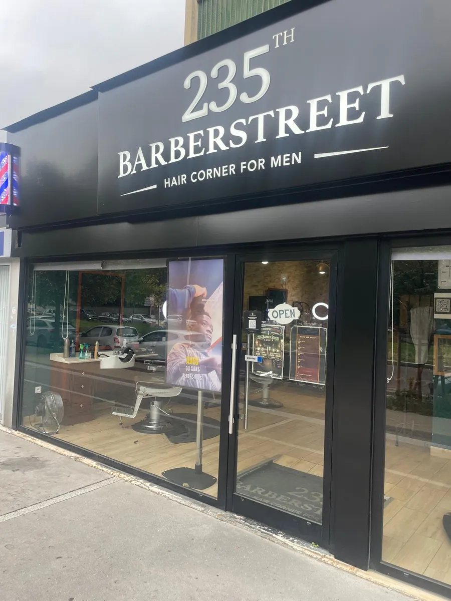 Devanture noire du barbershop 235th Barber Street, enseigne « 235th Barberstreet, Hair corner for men », au 75 avenue de Verdun à Ivry-sur-Seine