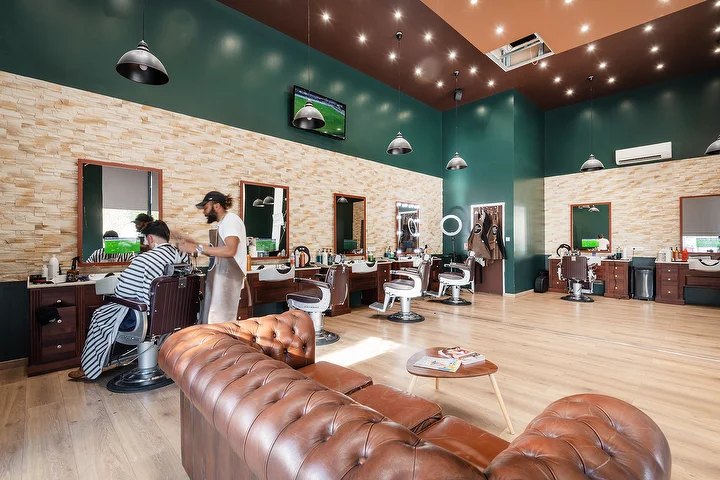 La salle du salon 235th Barber Street, avenue de Verdun à Ivry-sur-Seine : fauteuils, mur en pierre et canapé Chesterfield